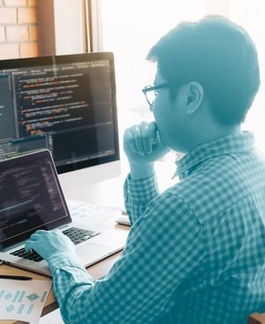 computer programmer looks at computer screens
