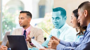 team of professionals sitting at a desk